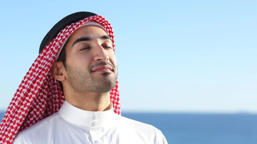 رجل بزي عربي يمارس التنفس العميق لإبعاد التوتر
